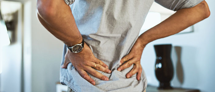 man holding lower back in pain